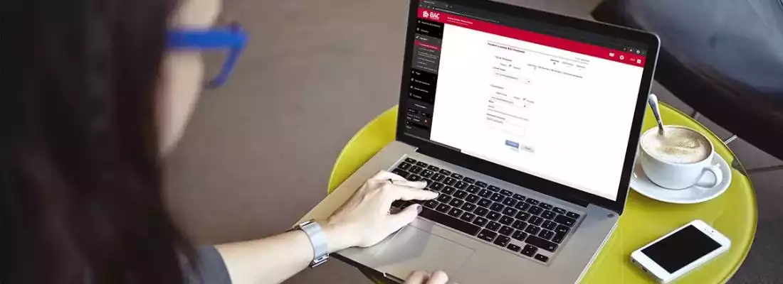 Persona usando computadora en portal de BAC Credomatic