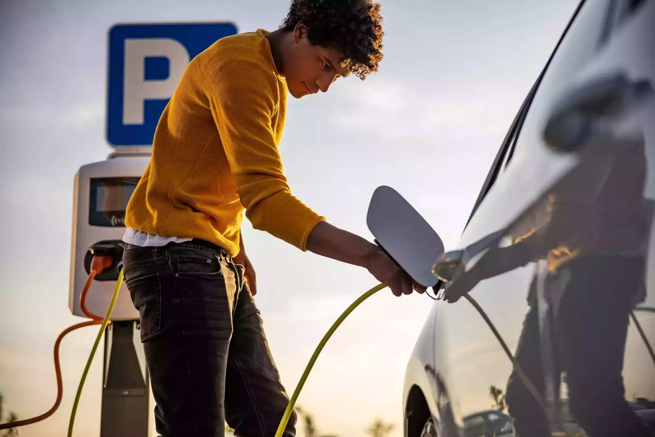 Hombre cargando vehículo eléctrico 