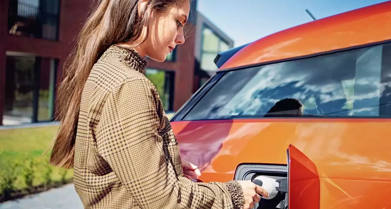 Chica recargando automóvil 