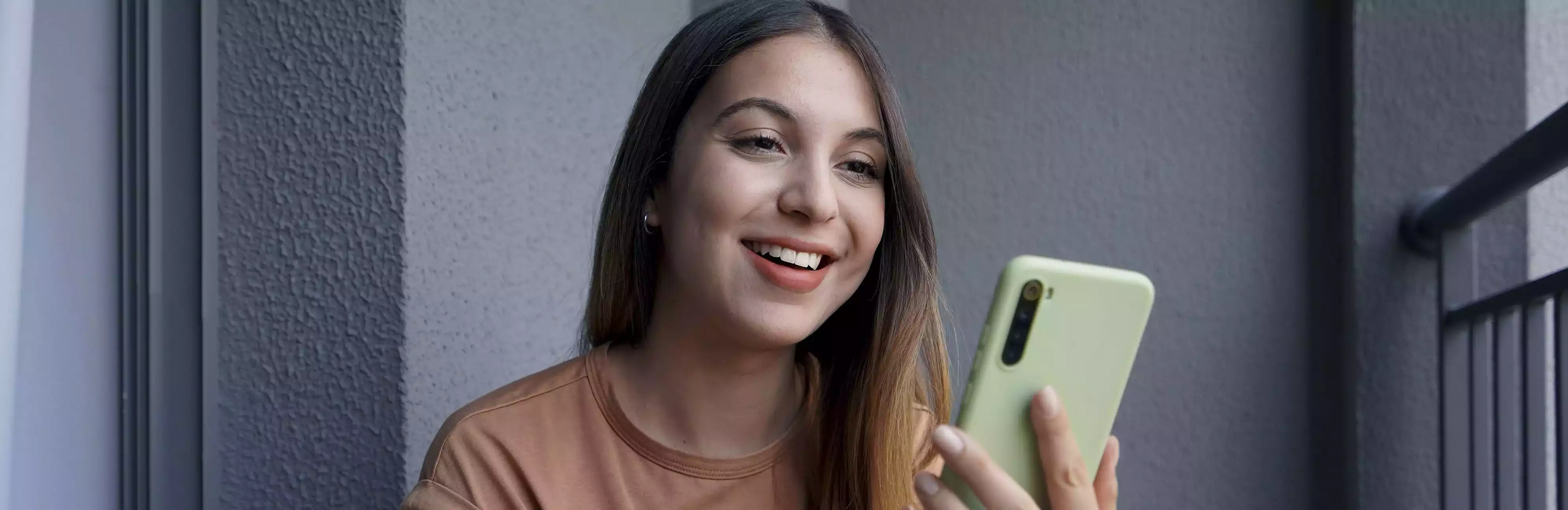 Imagen del banner de la landing, mujer con teléfono en la mano.