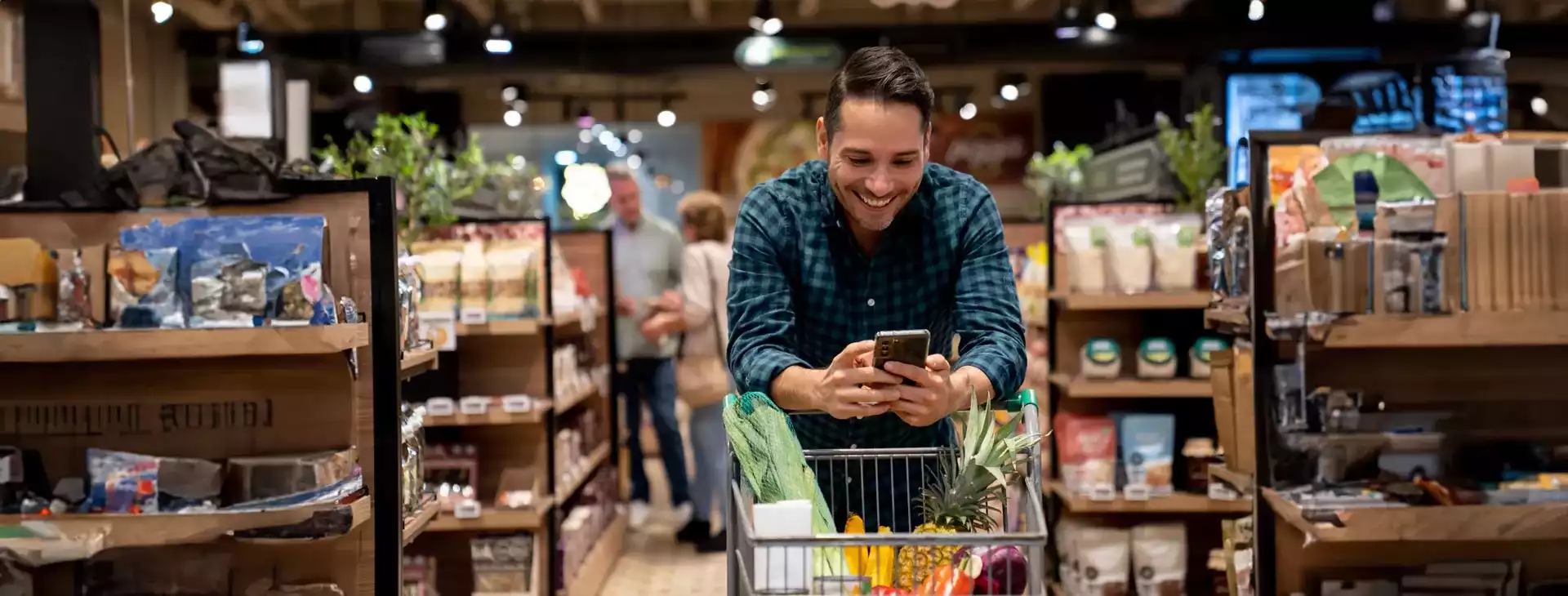 Persona viendo su telefono promociones Cashback 