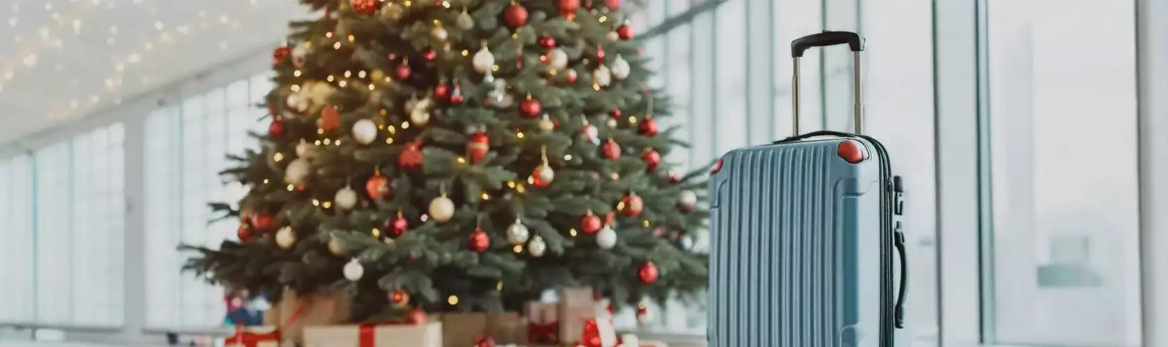 maleta en aeropuerto con arbol de navidad al fondo