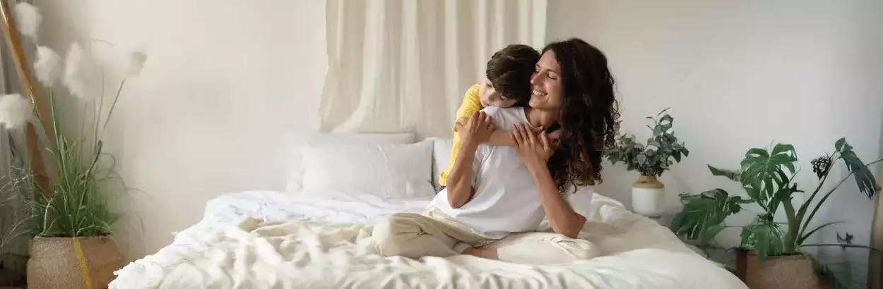 Madre e hija disfrutando de la comodidad de su cama